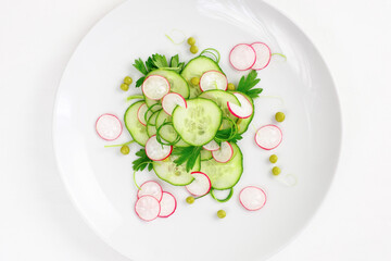 Cucumber and radish salad on a white plate