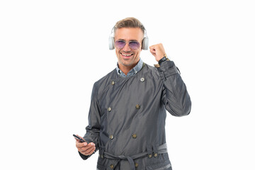 Happy man listening to music making winning gesture. Music player in smartphone. Mobile music