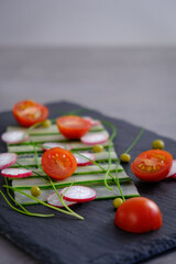 tomato, radish  and cucumber salade on the black plate