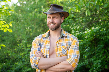 cheerful west man in cowboy hat. west cowboy in checkered shirt. western cowboy wearing west hat