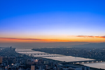 沈み行く夕陽に照らされる大阪の街並みと淀川【大阪風景】
