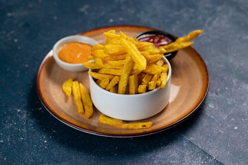 Crispy French Fries or potato chips with mayo dip and tomato sauce served in a plate side view view