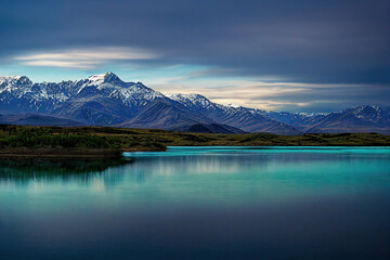 Mountains with snowy peaks on the shore of a beautiful lake. Abstract landscape. 3d illustration