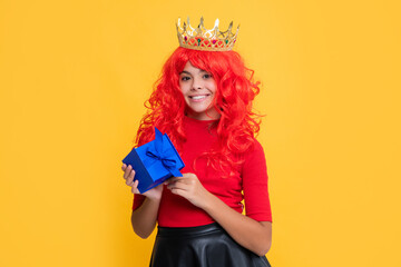 positive child in tiara with present box on yellow background