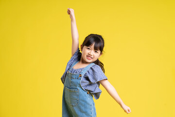 portrait of a beautiful asian girl, isolated on yellow background