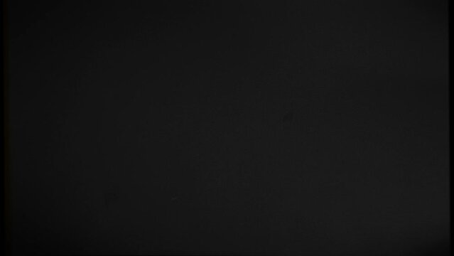 Damaged vintage film effect. Black background with flickering, scratches and damage to the film from long-term use.