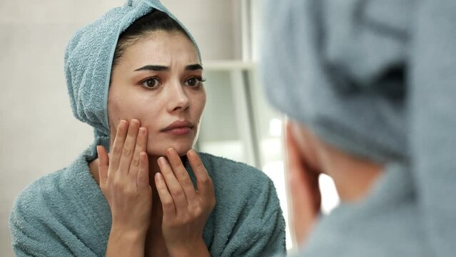 Woman squeezing a pimple on her face