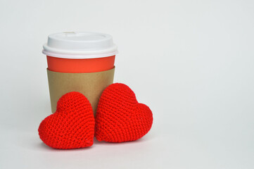 a glass for hot drinks, tea and coffee. background for the design. two red hearts, valentine's day, love.