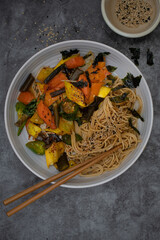 Vegan stir fry with noodles: carrot, squash and sea weed tubes