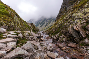 Impressive landscape with large grey-brown mountains in the Polish Tartars with a rocky hiking path