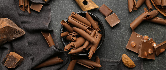 Chocolate pieces and curls on grunge background, top view