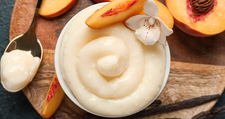 Bowl of delicious vanilla pudding and peaches on table, closeup