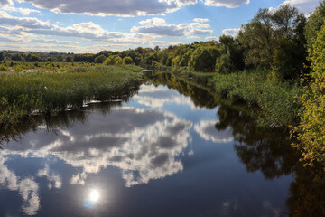 beautiful landscape, river flowing into the distance, the sun and clouds are reflected in the water