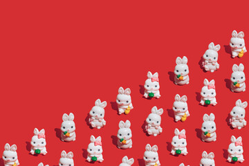 Seamless pattern made of little white rabbits on vibrant red background. Symbol of the Chinese New...