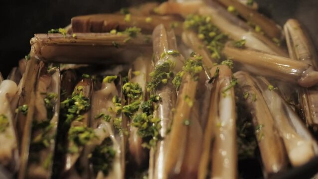 Razor clams seafood grilled on market, grill Spanish Navajas, traditional food in Spain, Catalonia, Barcelona.