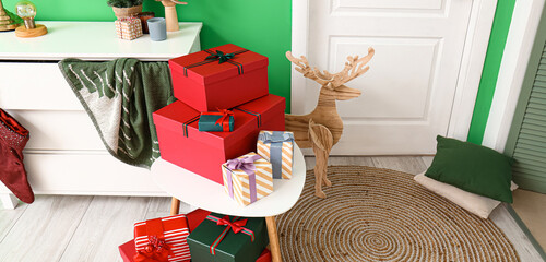 Christmas gifts and wooden reindeer near door in interior of room