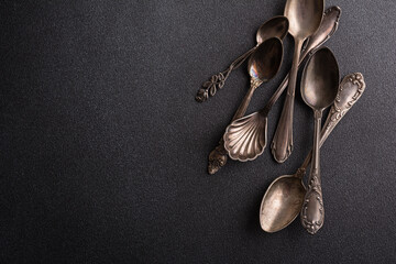 Set of vintage silver spoons on black background
