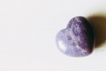 Pierre polie lépidolite lilas en forme de coeur sur un fond blanc - Minéral naturel