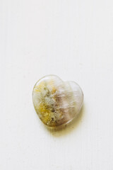 Pierre polie fluorite en forme de coeur sur un fond blanc - Minéral naturel