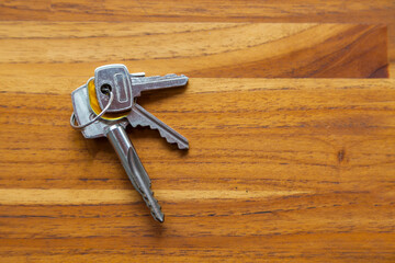 House door key on top of a wooden table. copy space. space for text. Key concept. Home concept.