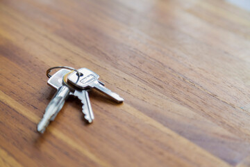 House door key on top of a wooden table. copy space. space for text. Key concept. Home concept.