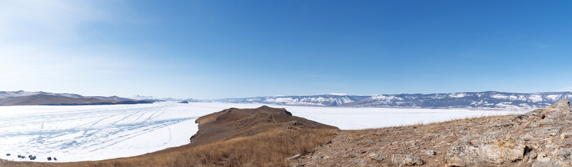 Winter landscape panorama with mountains and Lake Baikal in Siberia on sunny day. Natural background.