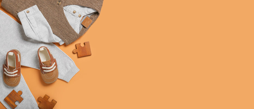 Stylish baby clothes on orange background with space for text - Powered by Adobe