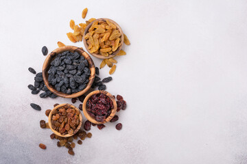 Wooden bowls with raisins and dried cranberries as ingredient for tasty dessert