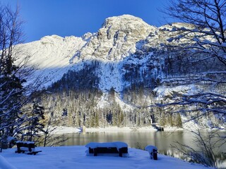 landscape with a bench in the snow and mountains at Lake Predil in winter on the Julian Alps