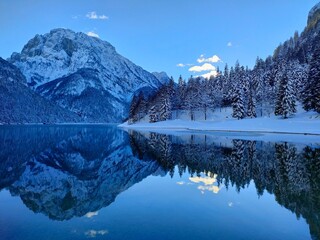 winter snowy landscape of mountains and reflection in Lake Predil on the Julian Alps