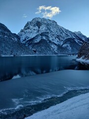 snow covered mountains with reflection in Lake Predil on the Julian Alps