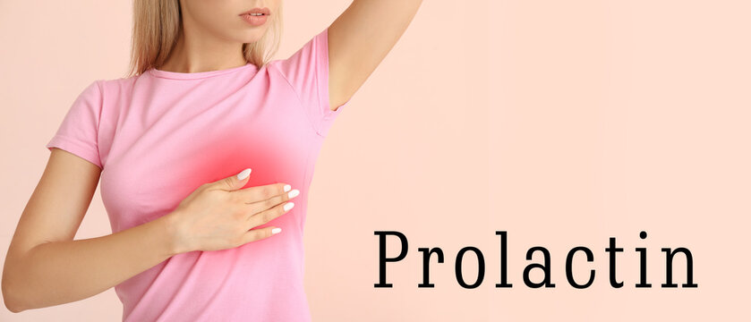 Young woman checking her breast on pink background. Prolactin and women's health