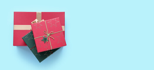 Christmas gift boxes on light blue background with space for text, top view