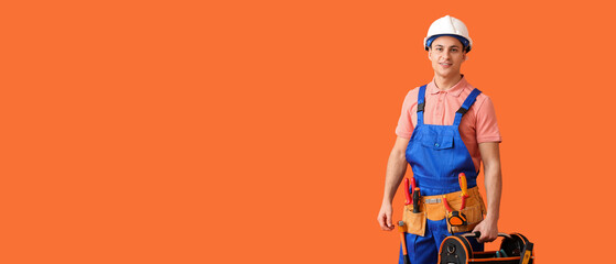 Young electrician with tools on orange background with space for text