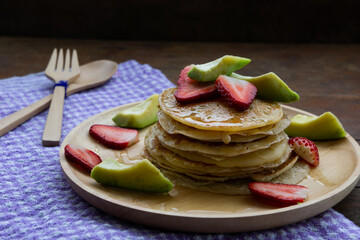 pancake strawberry avocado fruit and honey syrup sweeet dessert homemade and ready to eat on wood table.