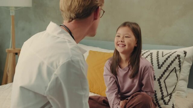 The doctor plays with an Asian girl and wishes her well.