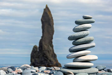 pyramid of smooth stones against the backdrop of a seascape. Rocks Fingers Troll. Iceland