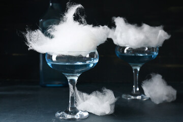 Glasses with delicious cotton candy cocktail on dark background