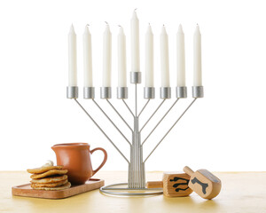 Menorah with candles, dreidels and potato pancakes for Hanukkah celebration on white background