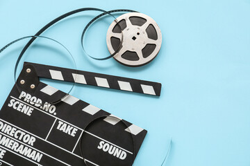 Movie clapper with reel on blue background