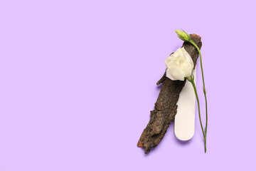 Composition with plaster podium, tree bark and eustoma flower on lilac background
