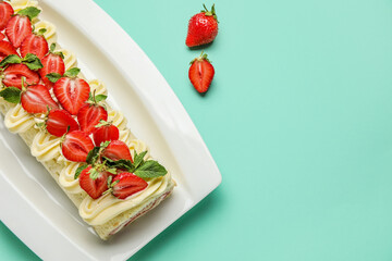 Plate with delicious strawberry roll cake on color background