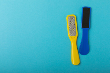 Pedicure tools.Pumice stone and foot file on a blue background. Close-up. FLAT LAY. Space for text, space for copy. - obrazy, fototapety, plakaty