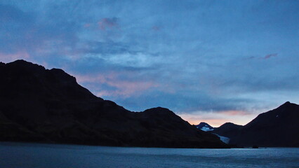 Sunset over a glacier in the mountains near Fortuna Bay, South Georgia Island