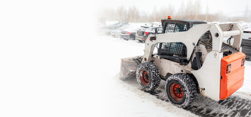 Snow clearing. Tractor clears the way after heavy snowfall. A large orange tractor removes snow...