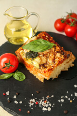Board with tasty Italian pie with mozzarella and pesto sauce on light background, closeup