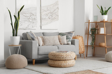 Interior of modern living room with sofa, poufs and 3D textile artwork