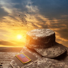 USA military uniform with insignias on old wooden table on sunset sky background with flying birds....