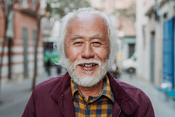 Portrait of happy Asian senior man smiling in front of camera