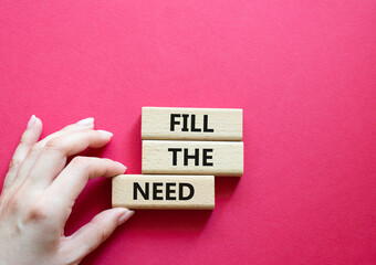 Fill the need symbol. Concept word Fill the need on wooden blocks. Beautiful red background. Businessman hand. Business and Fill the need concept. Copy space